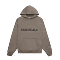 Essentials markalı bej kapüşonlu sweatshirt, önünde büyük yazılı logo ve kanguru cep
